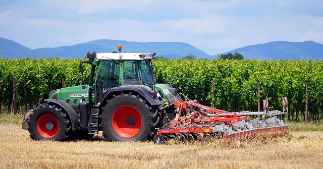 zelený traktor pri zbere úrody jesenné pole Slovensko